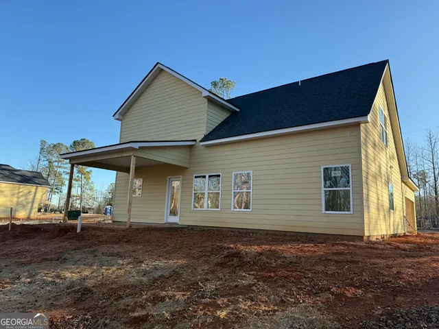 a backyard of a house with a table and chairs