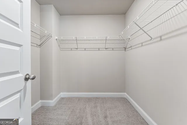 a view of a small space with racks on the wall and a window