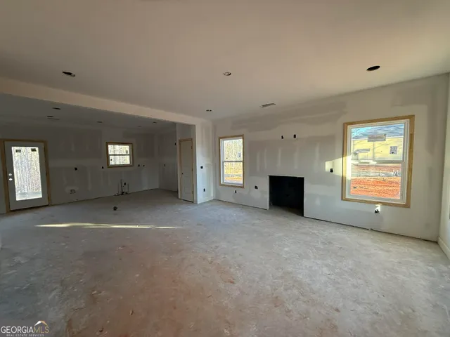 a view of an empty room with a fireplace and a window