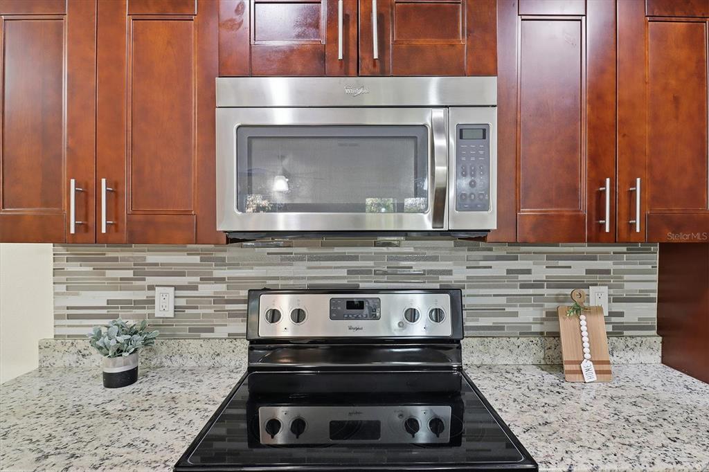 5041 Royal Palms Way, Unit 202 New Port Richey, FL 34652 - Photo 12 of 41 a stove top oven sitting inside of a kitchen
