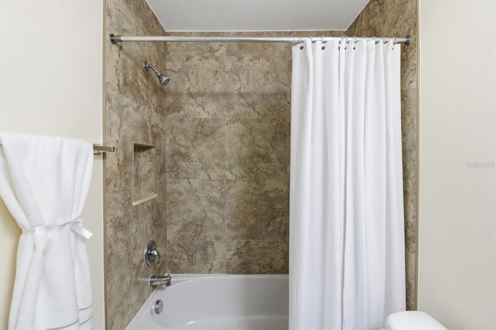 5041 Royal Palms Way, Unit 202 New Port Richey, FL 34652 - Photo 22 of 41 a bathroom with a shower and a tub