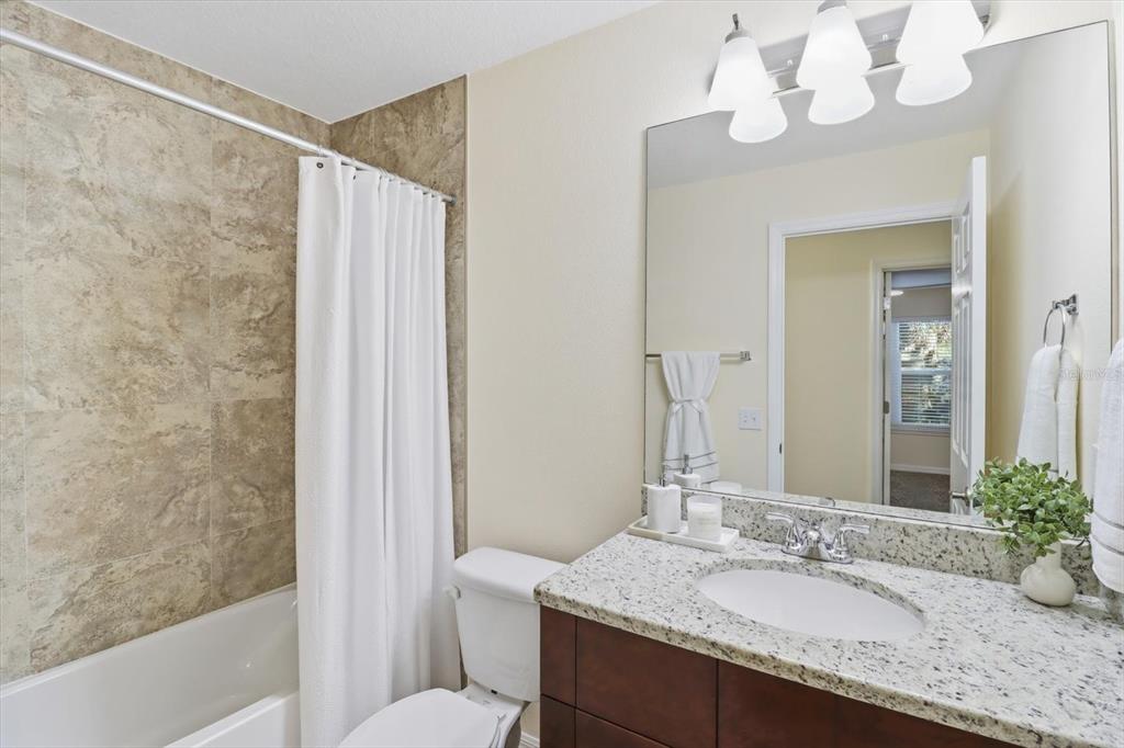5041 Royal Palms Way, Unit 202 New Port Richey, FL 34652 - Photo 3 of 41 a bathroom with a granite countertop sink a mirror and a bathtub