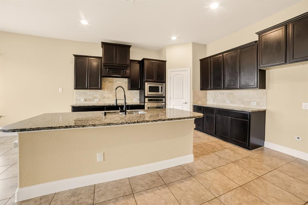 552 Winnetka Drive Oak Point, TX 75068 - Photo 19 of 40 a kitchen with stainless steel appliances granite countertop a refrigerator a stove a sink and a microwave