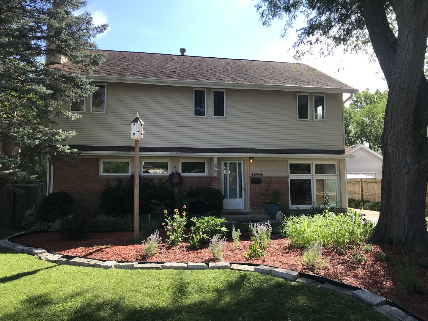 1009 Whitfield Road Northbrook, IL 60062 - Photo 2 of 25 a front view of a house with a yard and potted plants