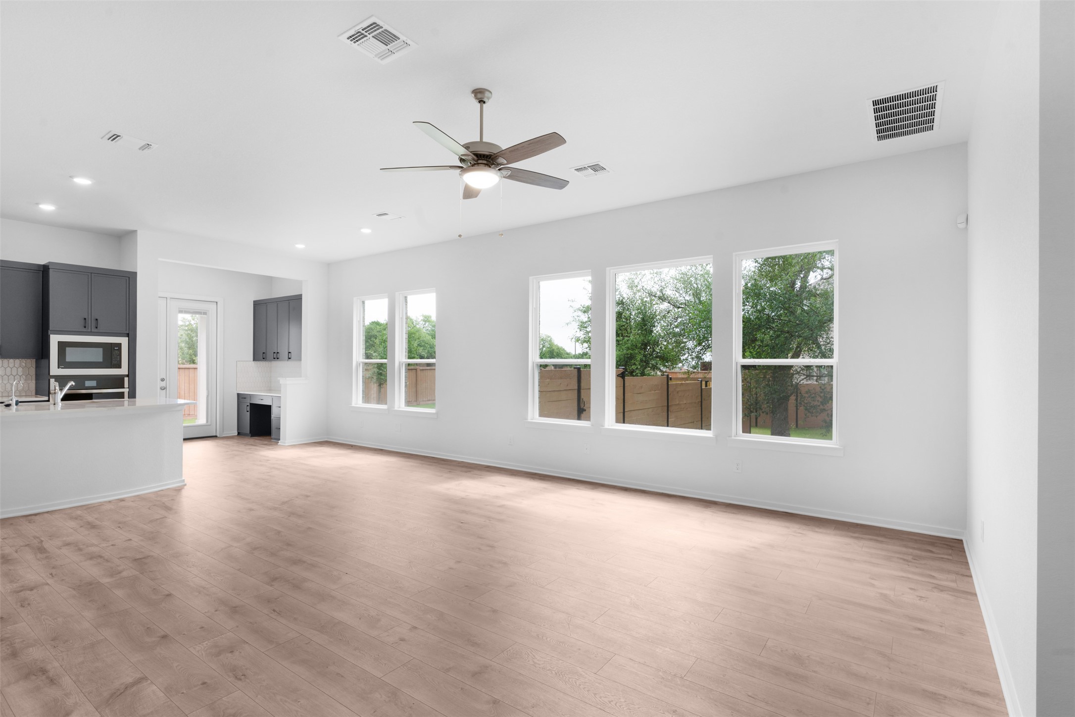 316 Ridgewell Loop Georgetown, TX 78633 - Photo 4 of 25 Expansive open-concept living area featuring light-colored flooring, recessed lighting, and a ceiling fan
