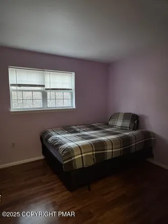 a bed sitting in a bedroom next to a window