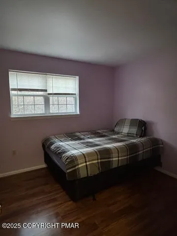 a bed sitting in a bedroom next to a window
