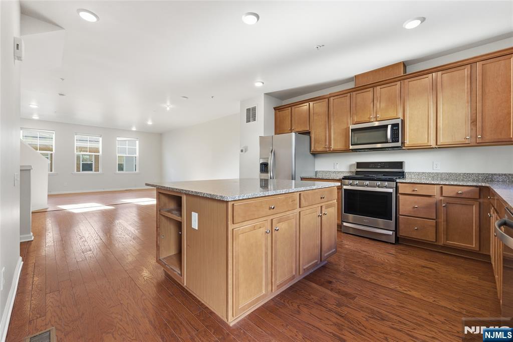 6 Bond Street North Brunswick, NJ 08902 - Photo 15 of 34 a kitchen with stainless steel appliances granite countertop a stove a sink and a microwave