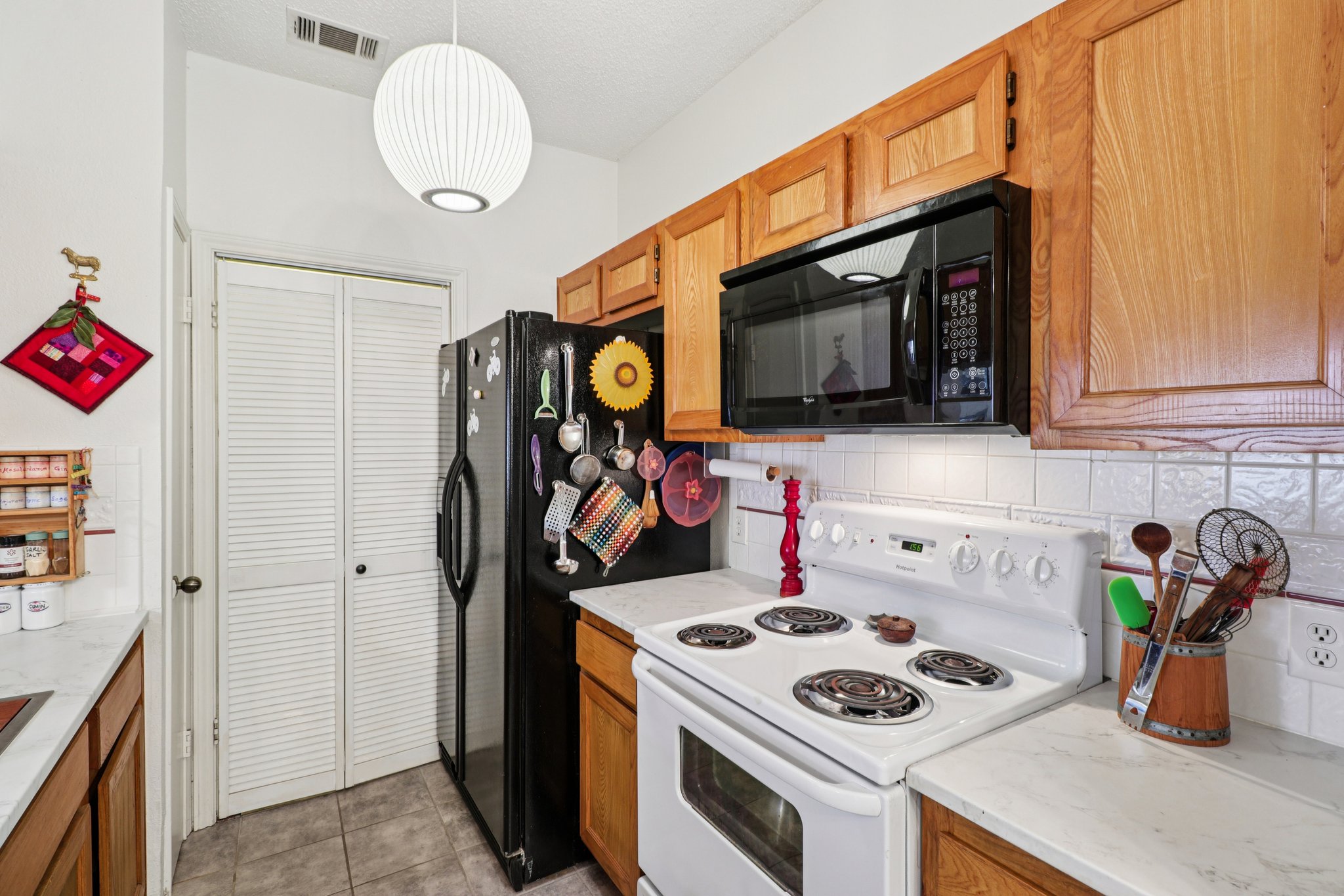 802 South 1st Street, Unit 121 Austin, TX 78704 - Photo 5 of 12 a utility room with fridge and wooden floor