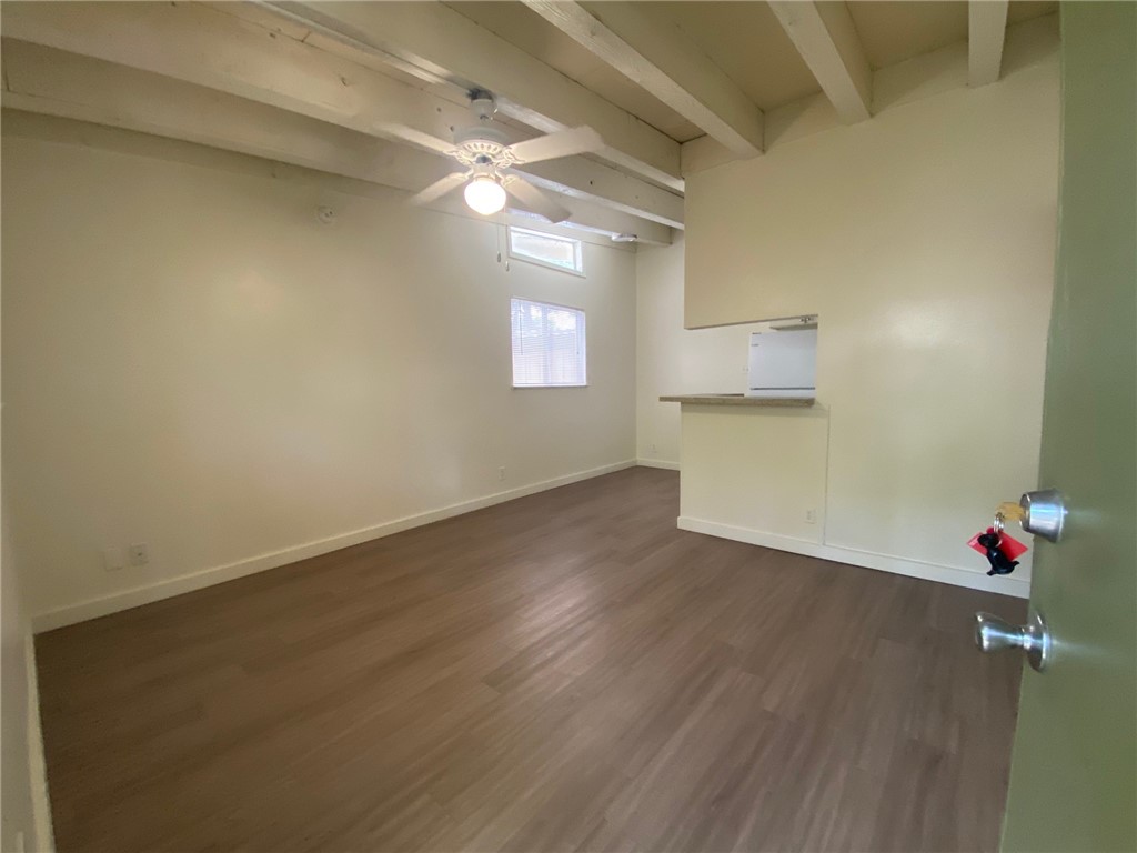an empty room with wooden floor and cabinets