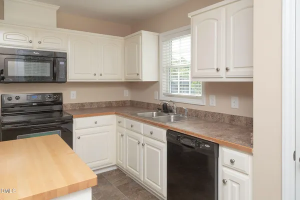a kitchen with granite countertop white cabinets and stainless steel appliances