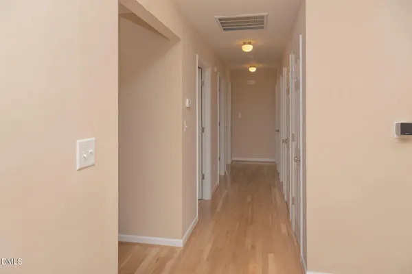a view of a hallway with wooden floor