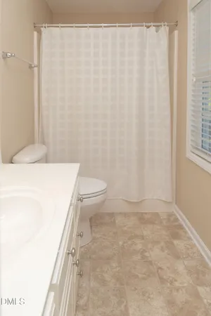 a bathroom with a shower a toilet and a sink