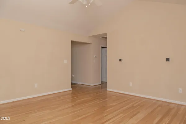 a view of an empty room with wooden floor