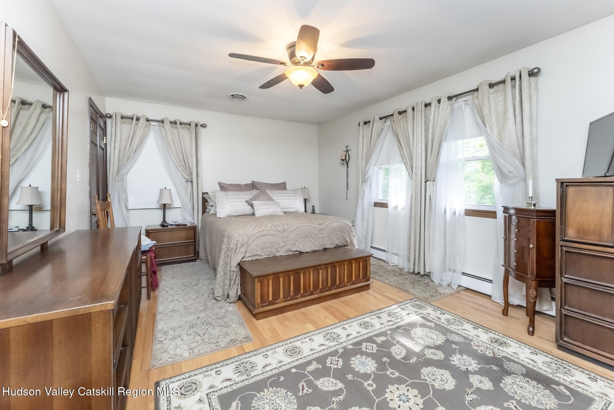 135 Hilltop Road Saugerties, NY 12477 - Photo 26 of 49 a living room with a balcony a bed furniture and a large window