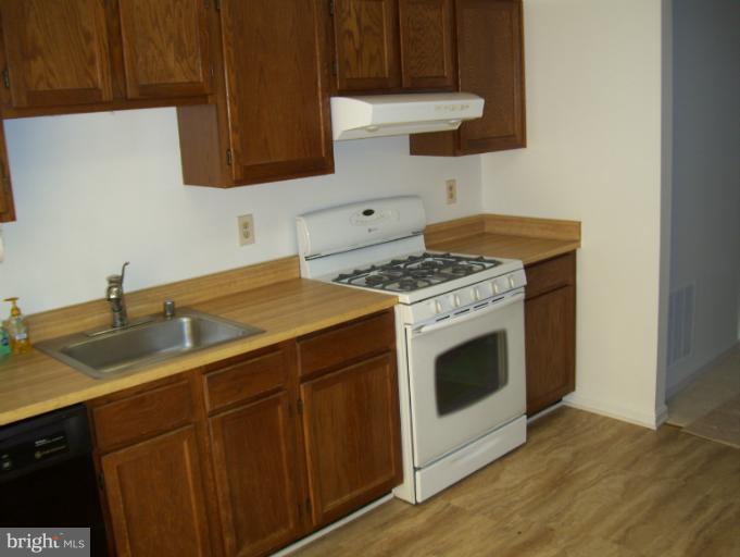 14432 Bakersfield Court Silver Spring, MD 20906 - Photo 5 of 11 a kitchen with a stove top oven sink and cabinets