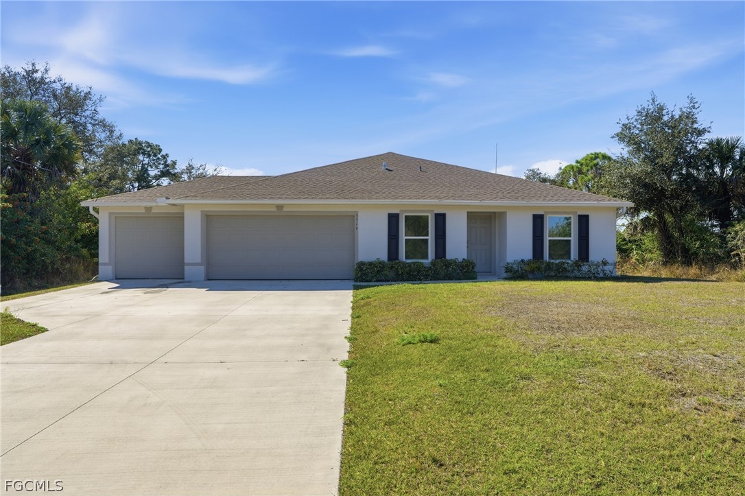 3319 40th Street West Lehigh Acres, FL 33971 - Photo 1 of 45 a front view of a house with a garden
