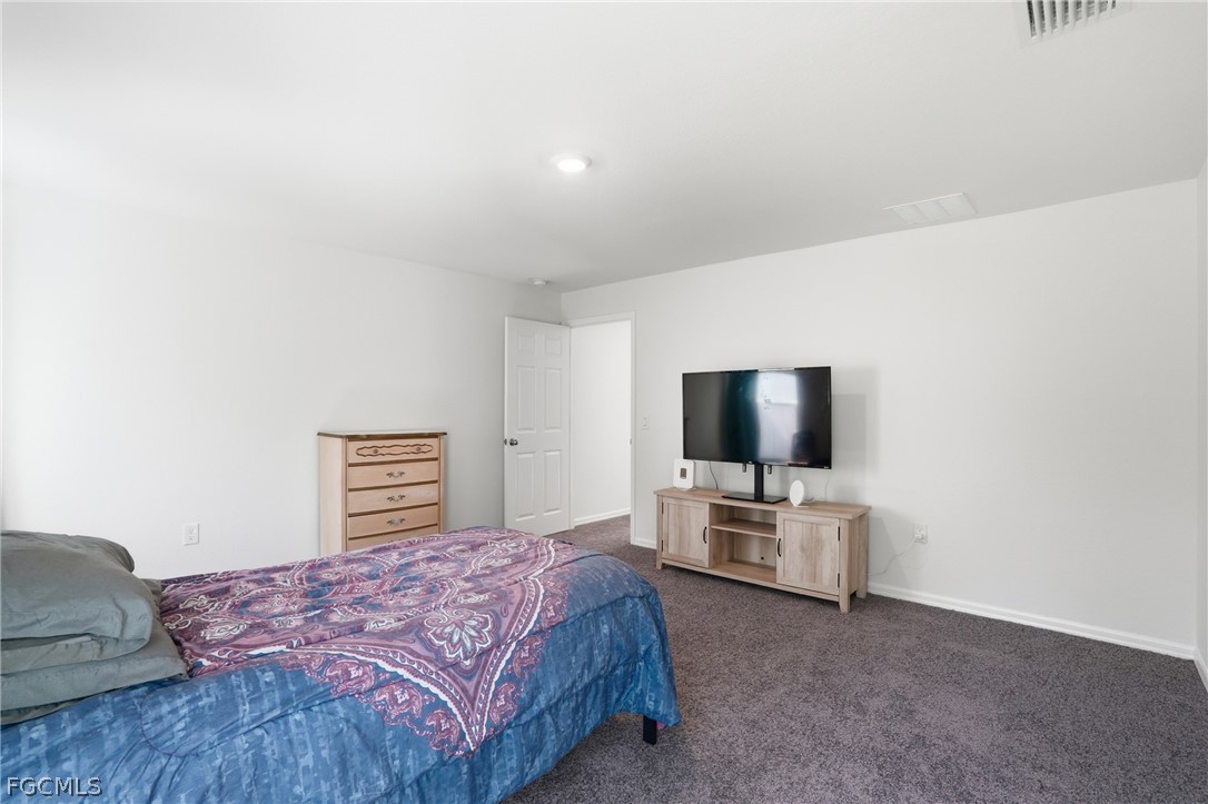 3319 40th Street West Lehigh Acres, FL 33971 - Photo 22 of 45 a bedroom with a bed and flat screen tv