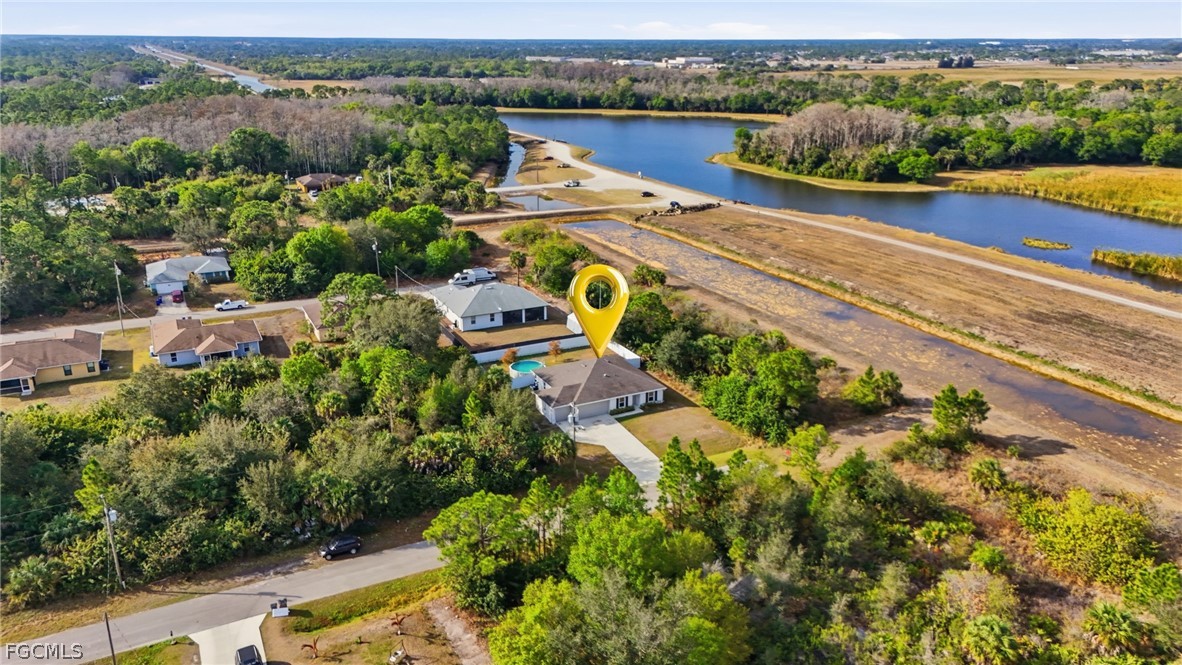 3319 40th Street West Lehigh Acres, FL 33971 - Photo 39 of 45 an aerial view of a house with a garden and lake view