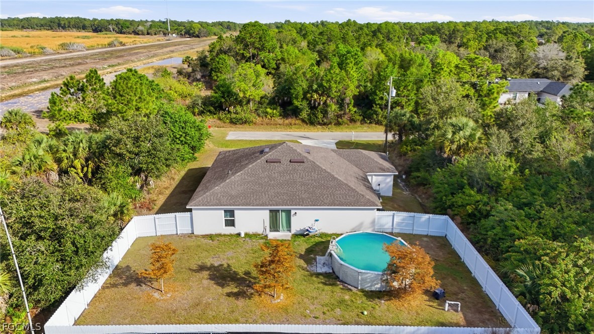 3319 40th Street West Lehigh Acres, FL 33971 - Photo 43 of 45 an aerial view of a house with swimming pool and green space