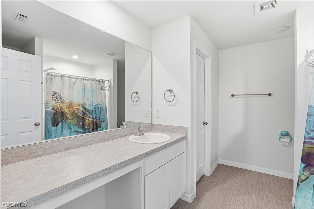 3319 40th Street West Lehigh Acres, FL 33971 - Photo 9 of 45 a bathroom with a granite countertop sink and a mirror