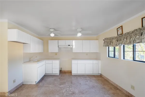 a kitchen with white cabinets and a sink