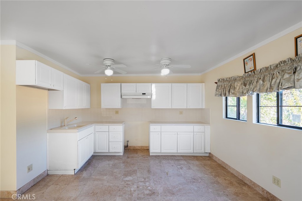 2240 Foothill Boulevard Santa Ana, CA 92705 - Photo 23 of 31 a kitchen with white cabinets and a sink