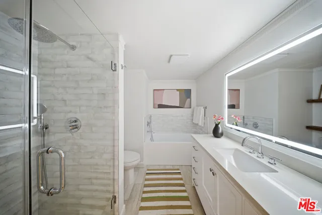 a bathroom with a tub a sink and window