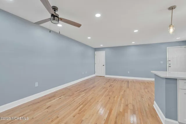 a view of empty room with wooden floor