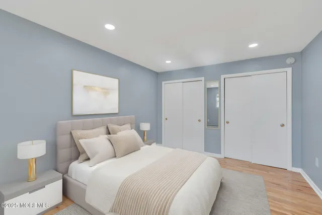 a spacious bedroom with a bed and a painting on the wall