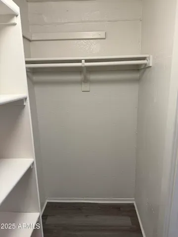 a view of walk in closet with empty racks