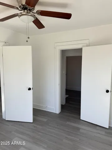 a view of a room with wooden floor and ceiling fan
