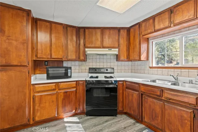 a kitchen with stainless steel appliances granite countertop wooden cabinets a sink and a stove