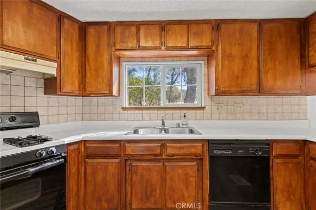 a kitchen with stainless steel appliances a stove sink and cabinets