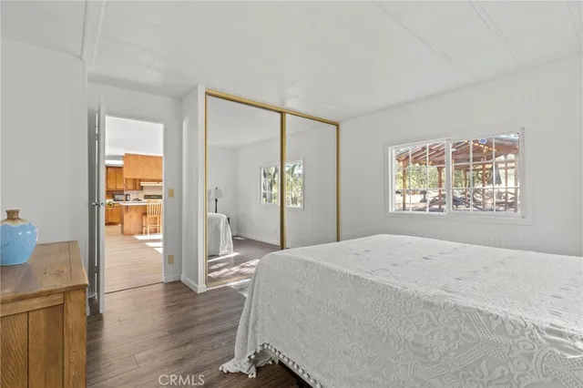 a spacious bedroom with a bed and wooden floor