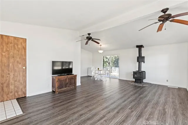 a view of a livingroom with wooden floor and a ceiling fan