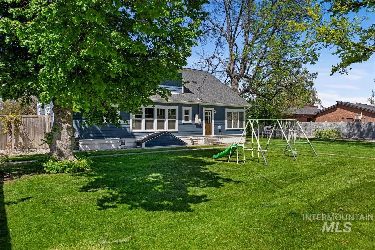 813 7th Street Rupert, ID 83350 - Photo 40 of 48 Expansive rear yard featuring a manicured lawn, mature trees, and privacy fencing