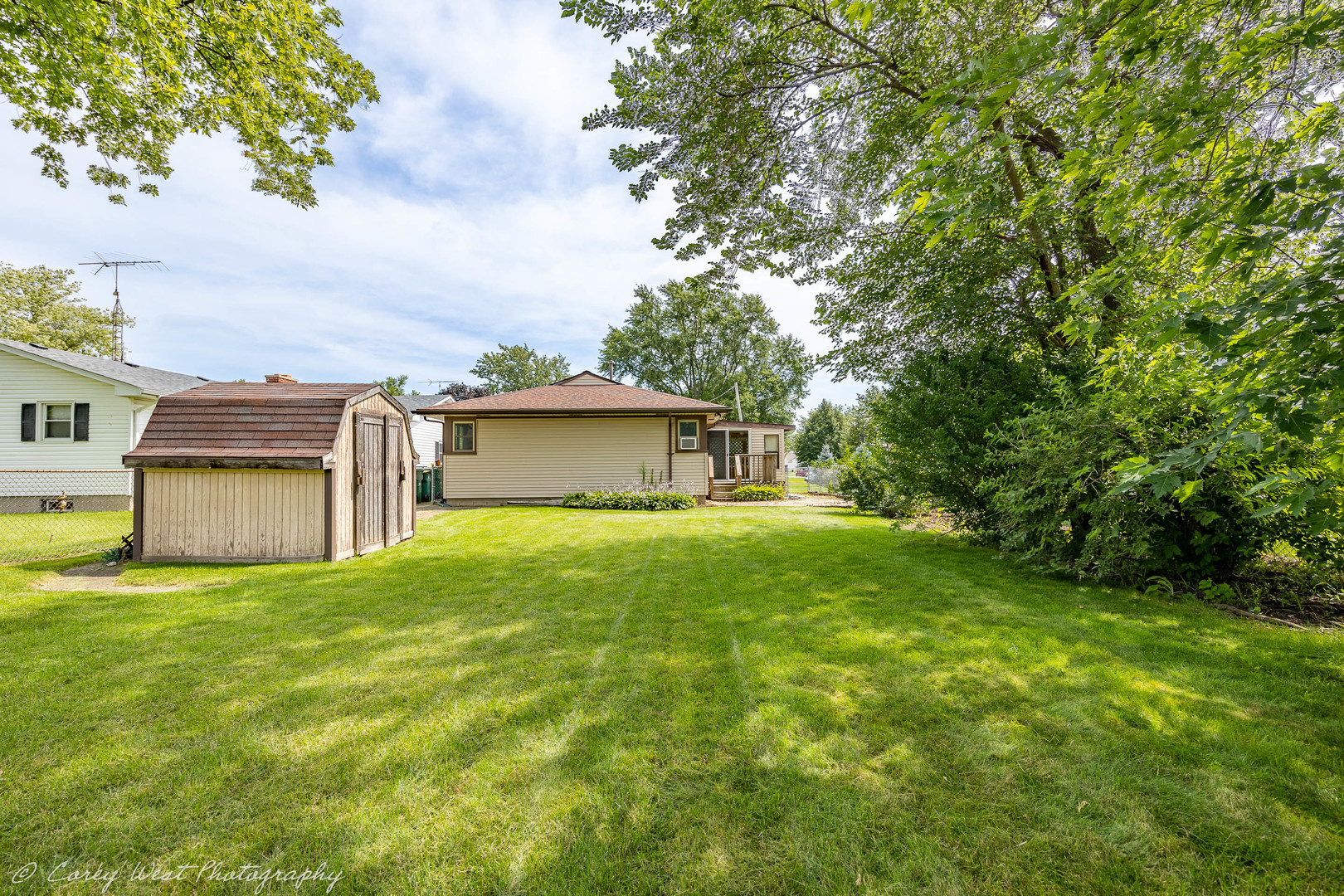 1233 Wild Street Sycamore, IL 60178 - Photo 16 of 18 a tall yellow house with a big yard and large trees