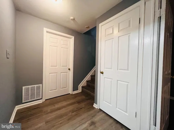 a view of a hallway with wooden floor and entryway