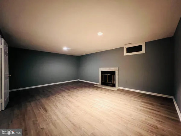 an empty room with wooden floor and fireplace
