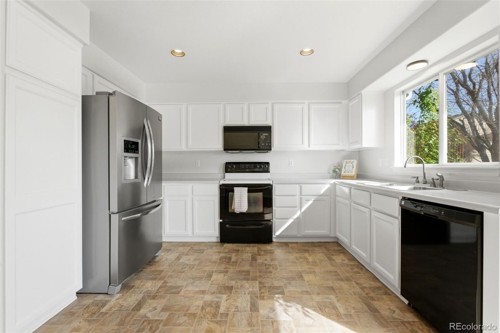 2164 South Waco Street Aurora, CO 80013 - Photo 17 of 50 a kitchen with a refrigerator sink and microwave