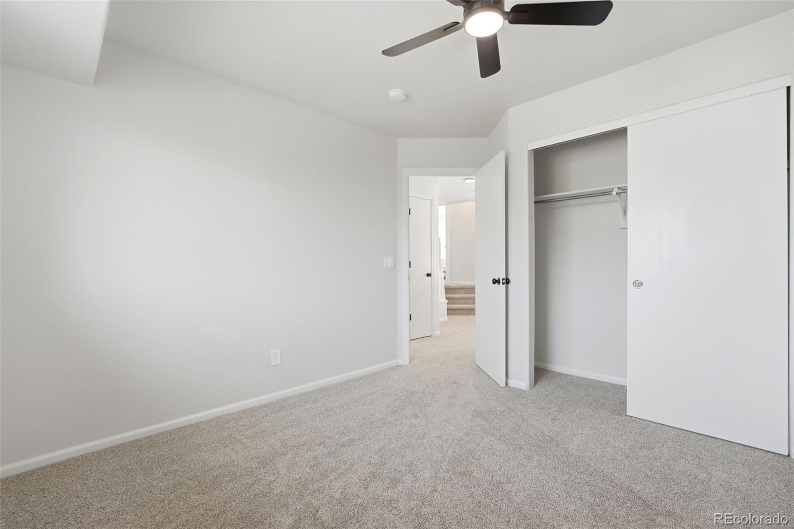 2164 South Waco Street Aurora, CO 80013 - Photo 43 of 50 an empty room with a ceiling fan and carpet