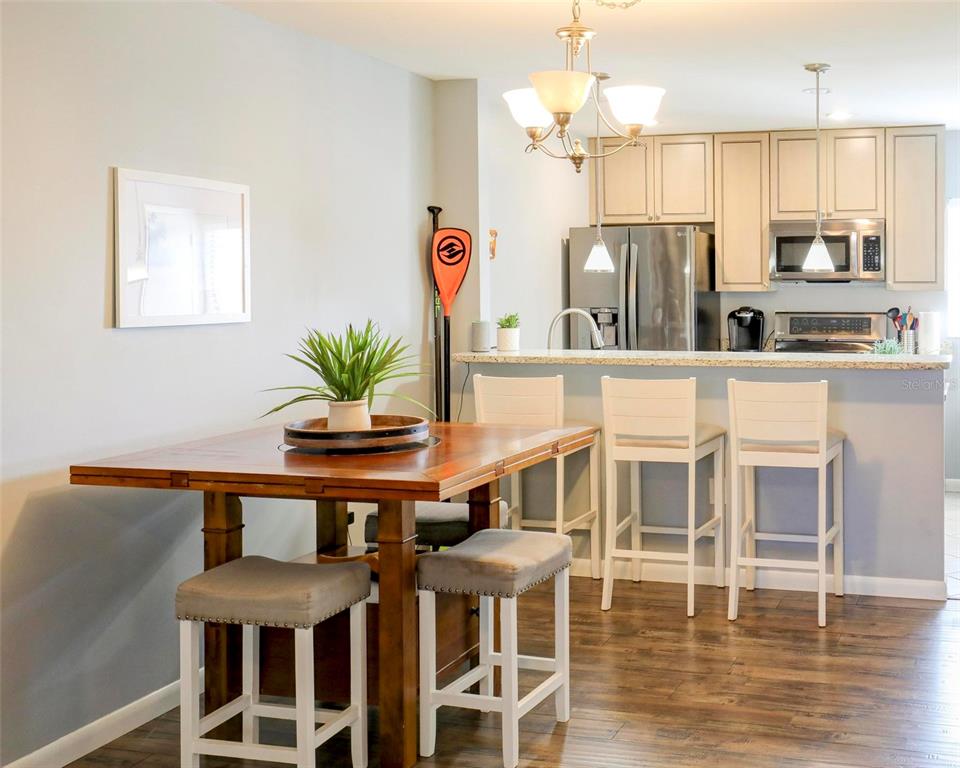 8911 Blind Pass Road, Unit 321 St. Pete Beach, FL 33706 - Photo 13 of 55 a kitchen with stainless steel appliances granite countertop a dining table chairs and a refrigerator