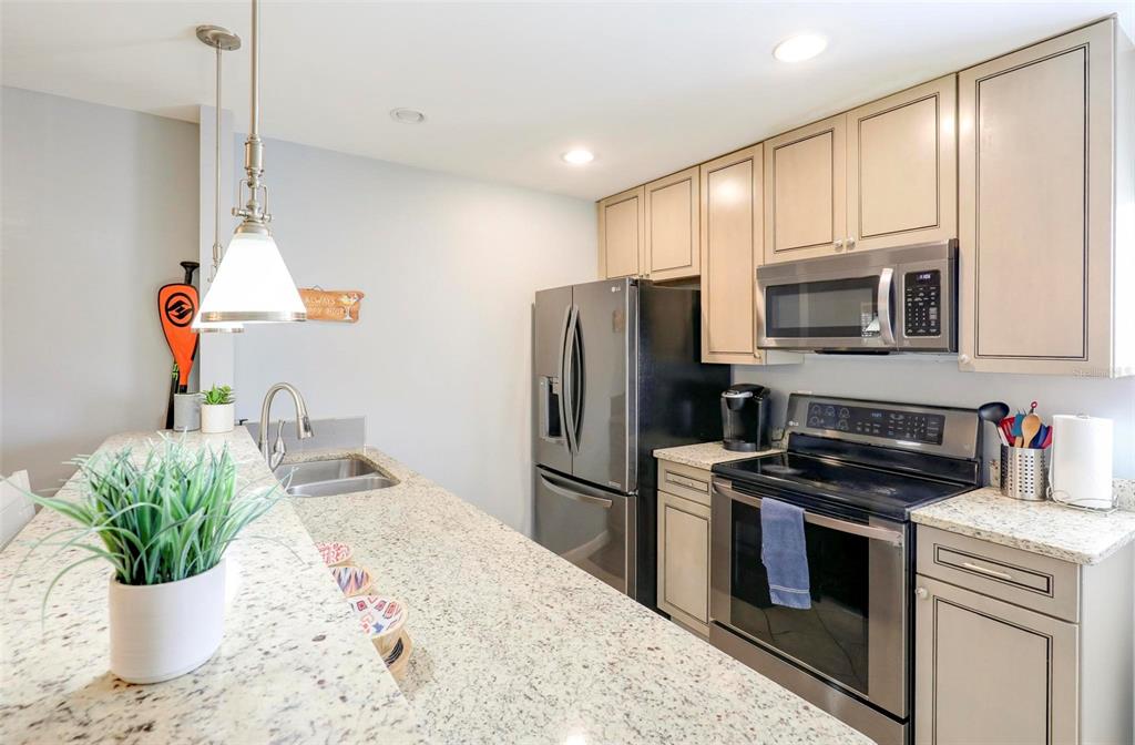 8911 Blind Pass Road, Unit 321 St. Pete Beach, FL 33706 - Photo 16 of 55 a kitchen with a sink stainless steel appliances and cabinets