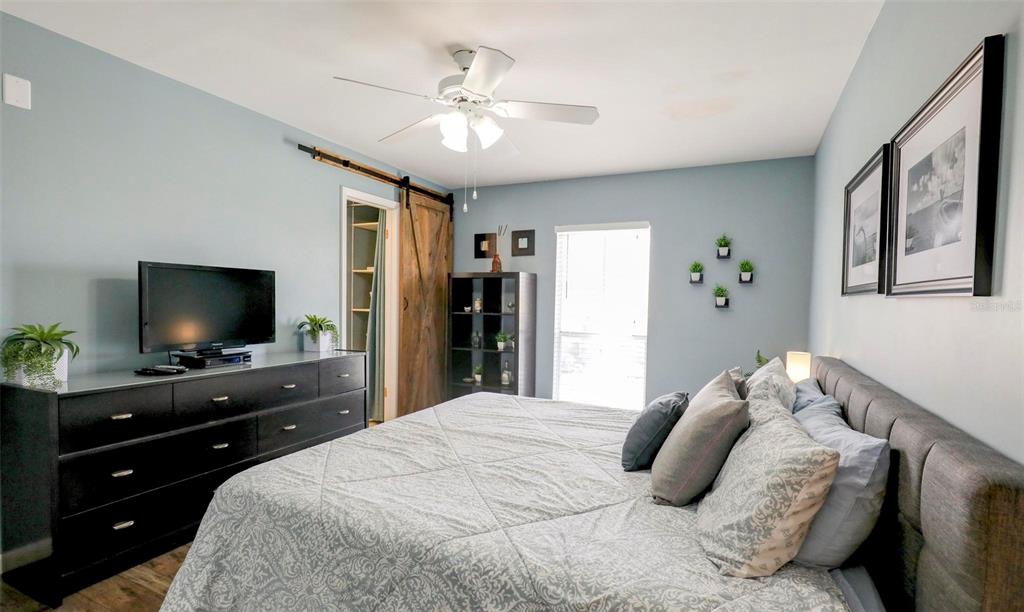 8911 Blind Pass Road, Unit 321 St. Pete Beach, FL 33706 - Photo 28 of 55 a bedroom with a large bed and a flat screen tv