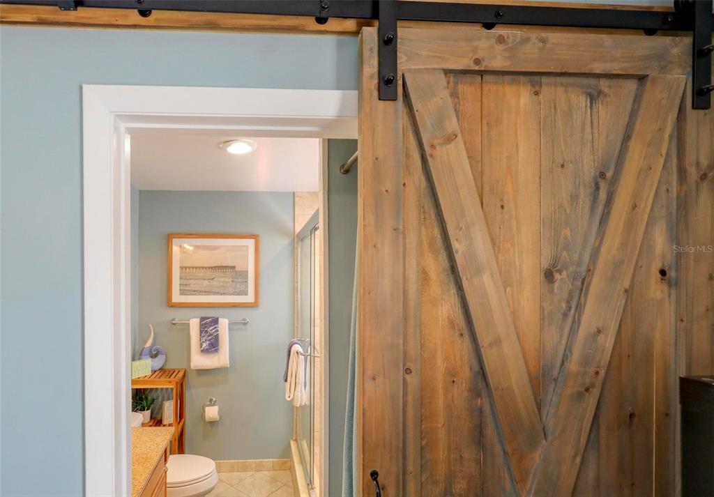 8911 Blind Pass Road, Unit 321 St. Pete Beach, FL 33706 - Photo 31 of 55 a bathroom with a shower curtain and a sink