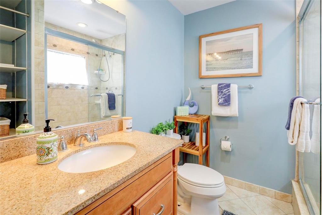 8911 Blind Pass Road, Unit 321 St. Pete Beach, FL 33706 - Photo 32 of 55 a bathroom with a sink toilet and a mirror