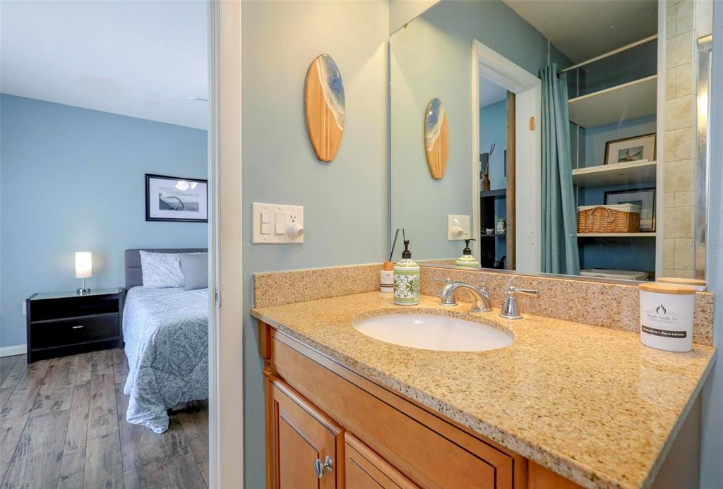 8911 Blind Pass Road, Unit 321 St. Pete Beach, FL 33706 - Photo 34 of 55 a en suite bathroom with a granite countertop sink and a mirror