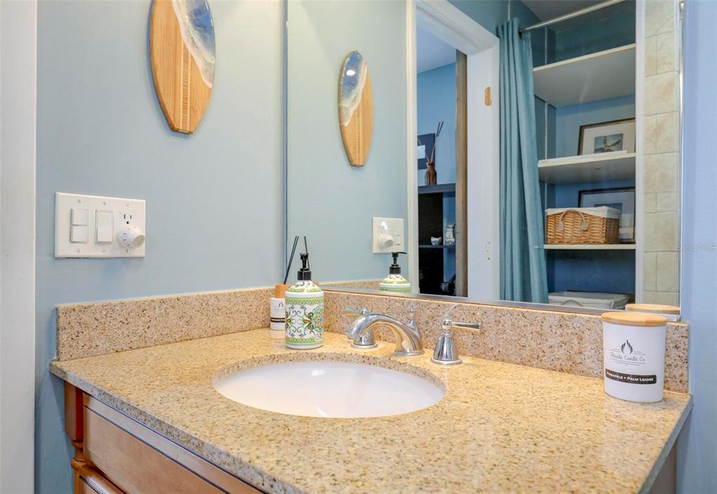 8911 Blind Pass Road, Unit 321 St. Pete Beach, FL 33706 - Photo 35 of 55 a bathroom with a granite countertop sink and a mirror