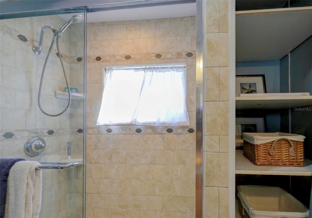 8911 Blind Pass Road, Unit 321 St. Pete Beach, FL 33706 - Photo 36 of 55 a bathroom with a granite countertop sink a toilet and shower